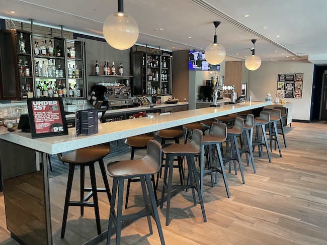 a bar with chairs and a sign