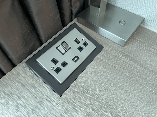 a rectangular electrical outlet with black and silver buttons