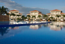 a pool with white buildings and palm trees