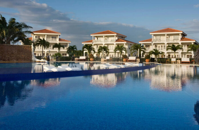 a pool with white buildings and palm trees