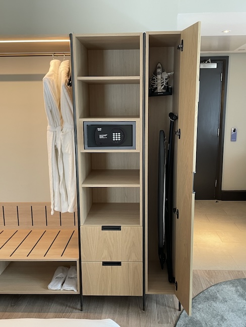 a locker with a door open and a white robe on a swinger