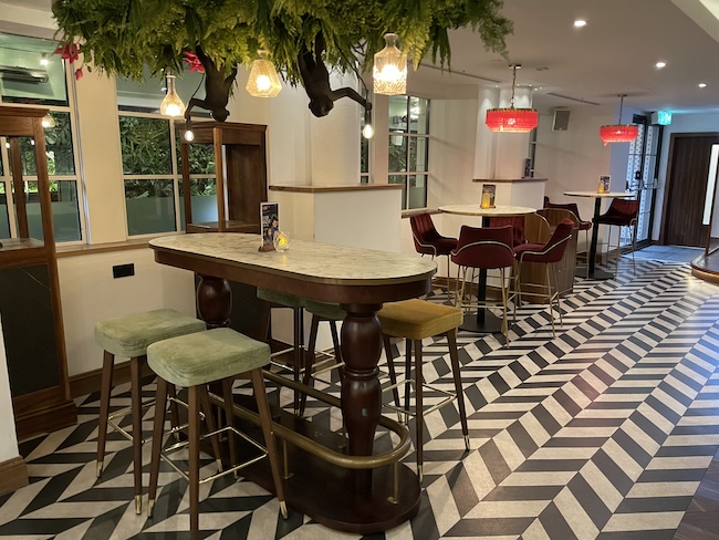 a bar with stools and tables in a room