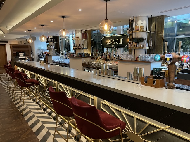 a bar with red chairs and a sign