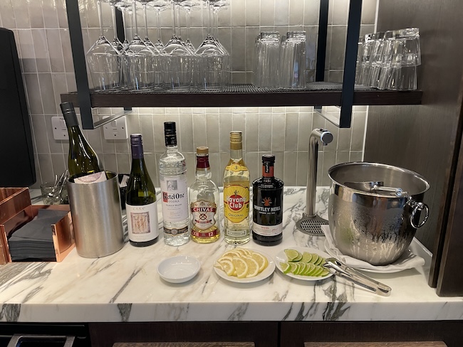 a bar with bottles of alcohol and glasses on a counter