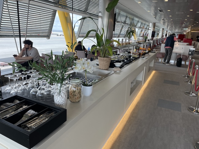 a buffet with a row of dishes and plants