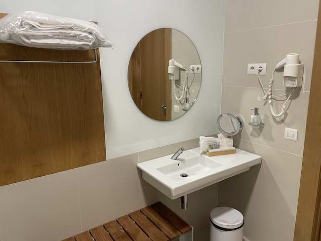 a bathroom with a round mirror and a sink