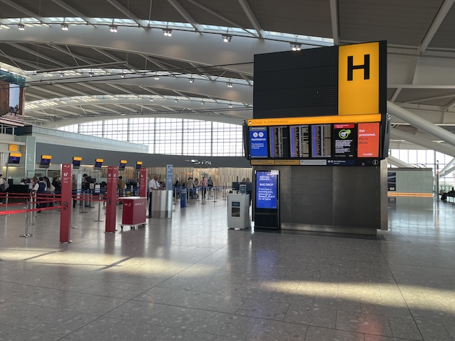 a large airport terminal with a sign and people walking around