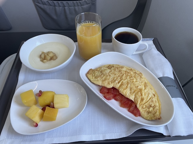 a plate of food and a drink on a tray