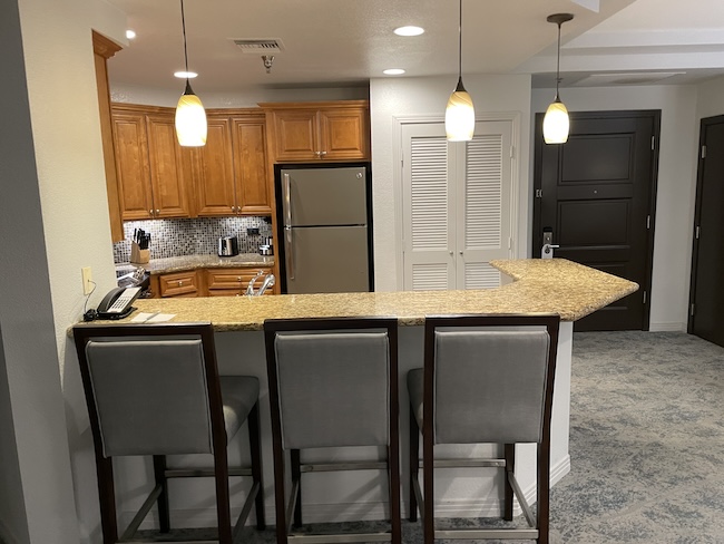 a kitchen with a bar and a refrigerator