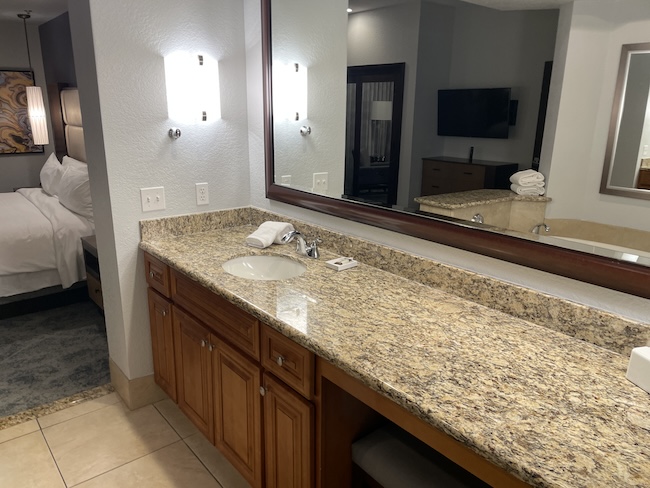 a bathroom with a large mirror and a marble countertop