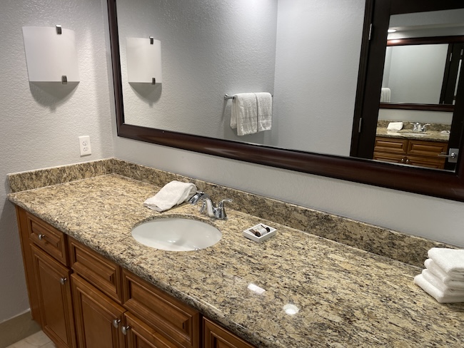 a bathroom with a marble countertop and a mirror