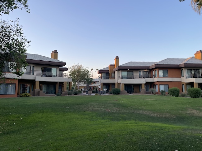 a green lawn with buildings in the background