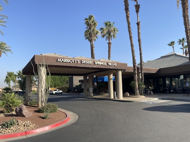 a building with palm trees and a parking lot