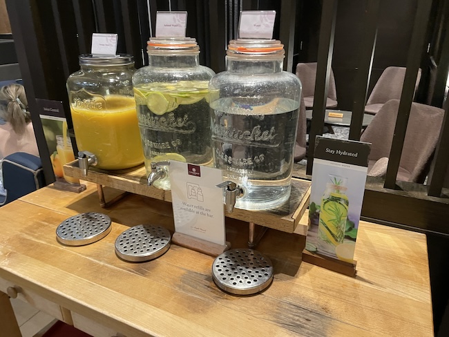 a group of glass jars with liquid and a drink dispenser