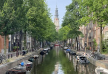 a canal with boats and trees in the background