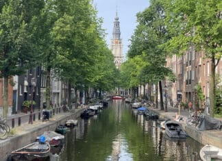 a canal with boats and trees in the background