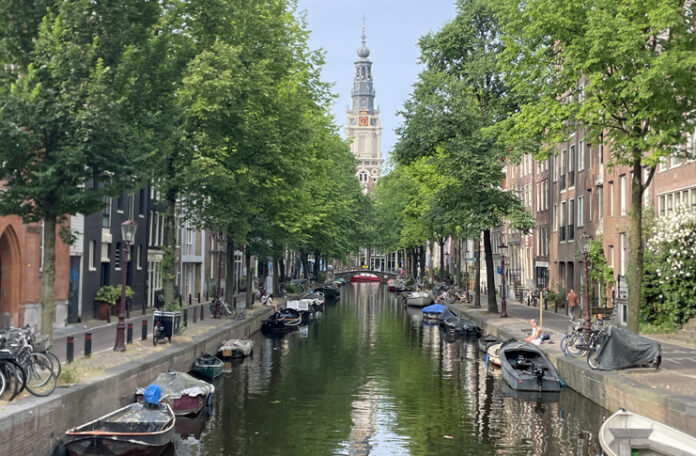 a canal with boats and trees in the background