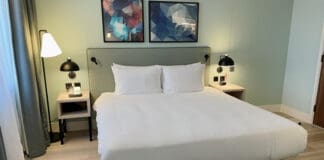 a bed with white sheets and pillows
