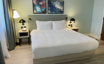 a bed with white sheets and pillows