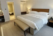 a bed with a bench and lamps in a room