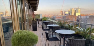 a patio with chairs and tables on a balcony