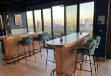 a bar with chairs and a view of a city