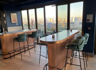 a bar with chairs and a view of a city