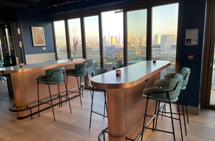 a bar with chairs and a view of a city