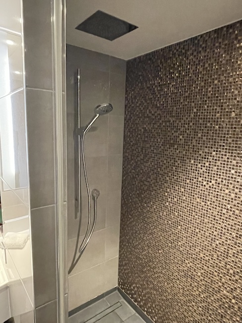 a shower with a tile wall