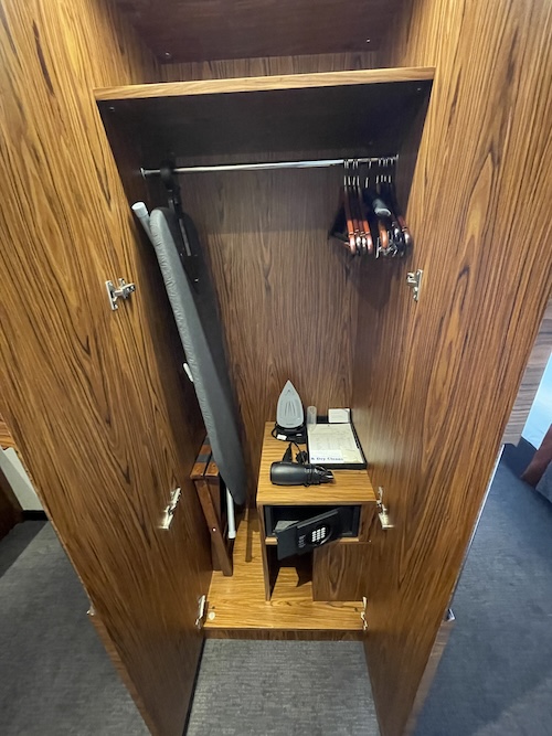 a wooden closet with irons and ironing board