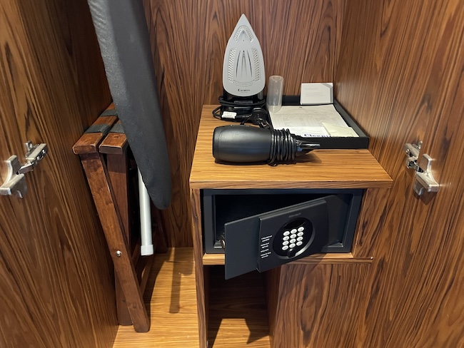 a ironing board and iron on a small wooden shelf