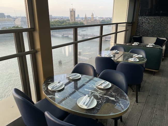 a table set up with chairs and a view of the city from a balcony