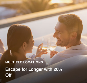 a man and woman sitting on a couch holding wine glasses