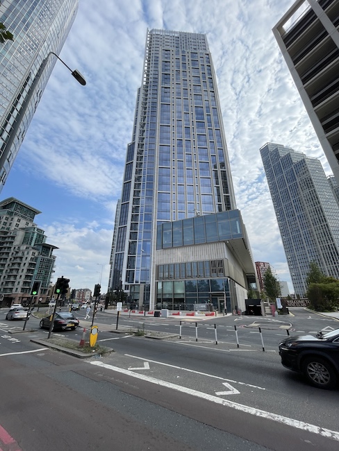 a tall building with a glass tower and a street light