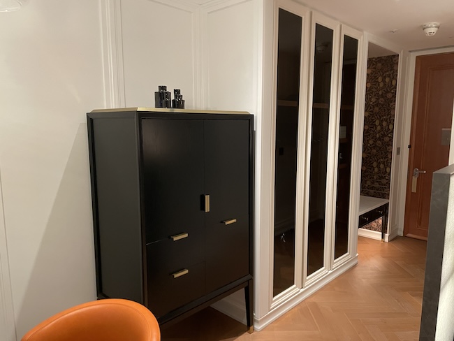 a black cabinet next to a white wall