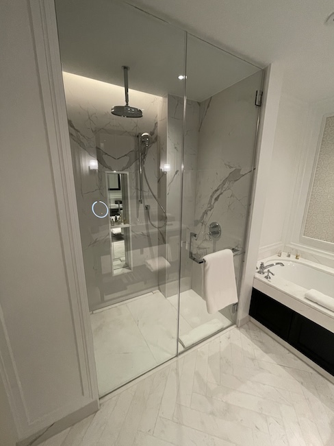 a bathroom with a glass shower and bathtub