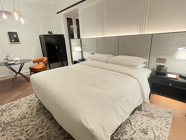 a bed with a white cover and a black cabinet