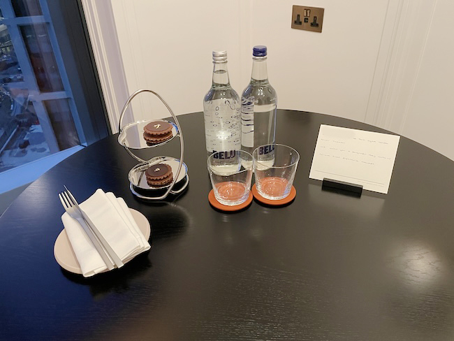 a table with a couple of glasses and a bottle of water