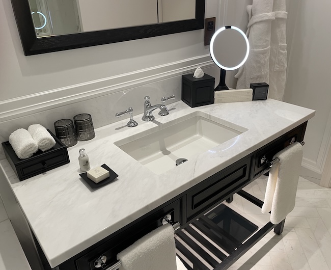 a bathroom sink with a mirror and towels