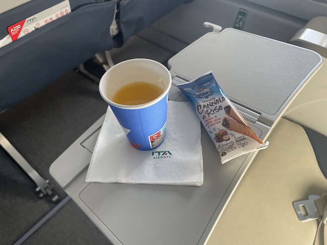 a cup of liquid and a snack on a table
