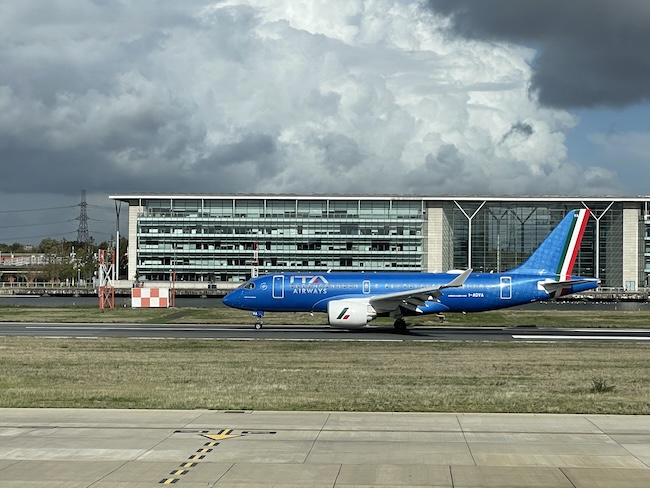 a blue airplane on a runway