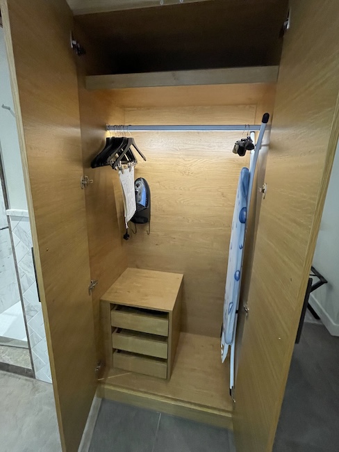 a closet with a shelf and swingers