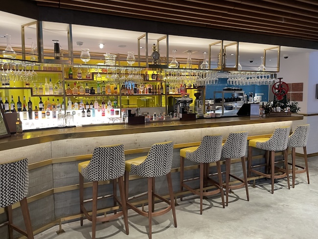 a bar with chairs and glasses