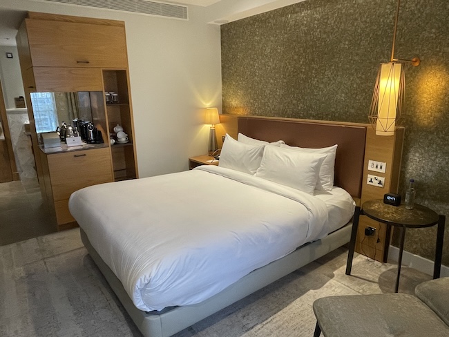 a bed with white sheets and a wood headboard