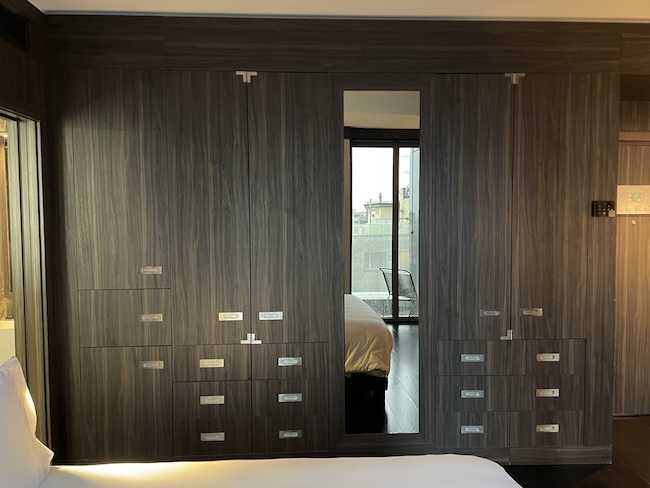a closet with drawers and a bed