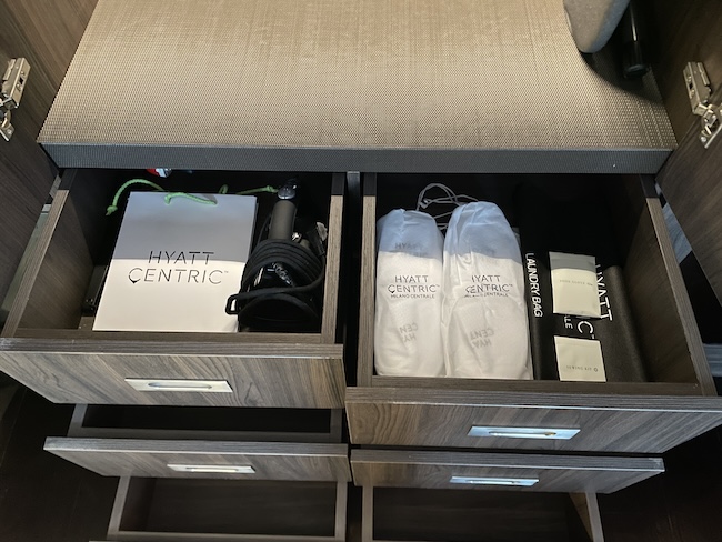 a drawer with white socks and a bag inside
