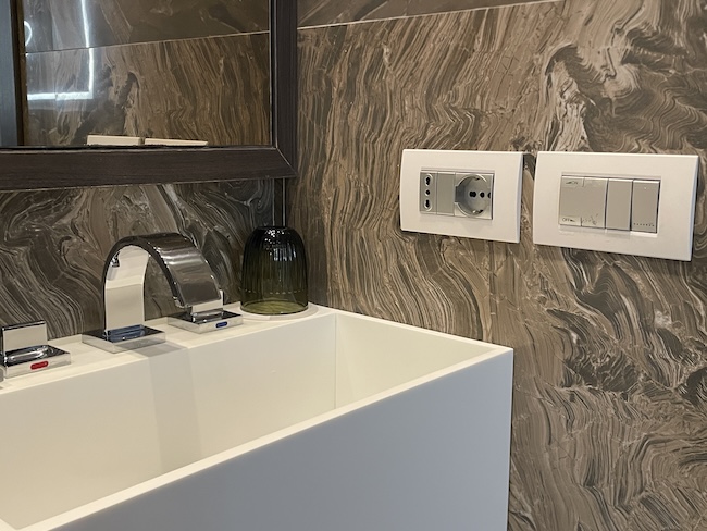 a sink and light switches in a bathroom