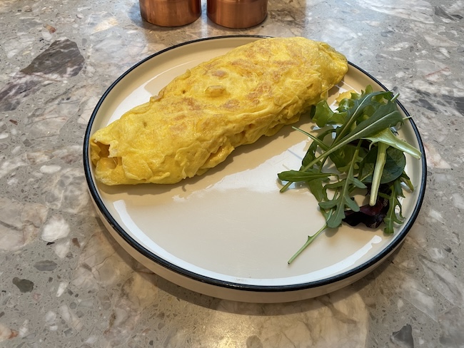 a omelette on a plate with a salad on it