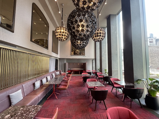 a room with tables and chairs and a large chandelier