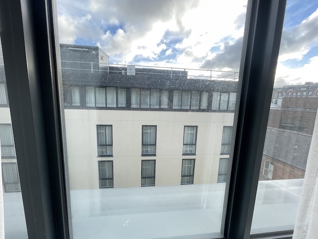 a window with a building in the background